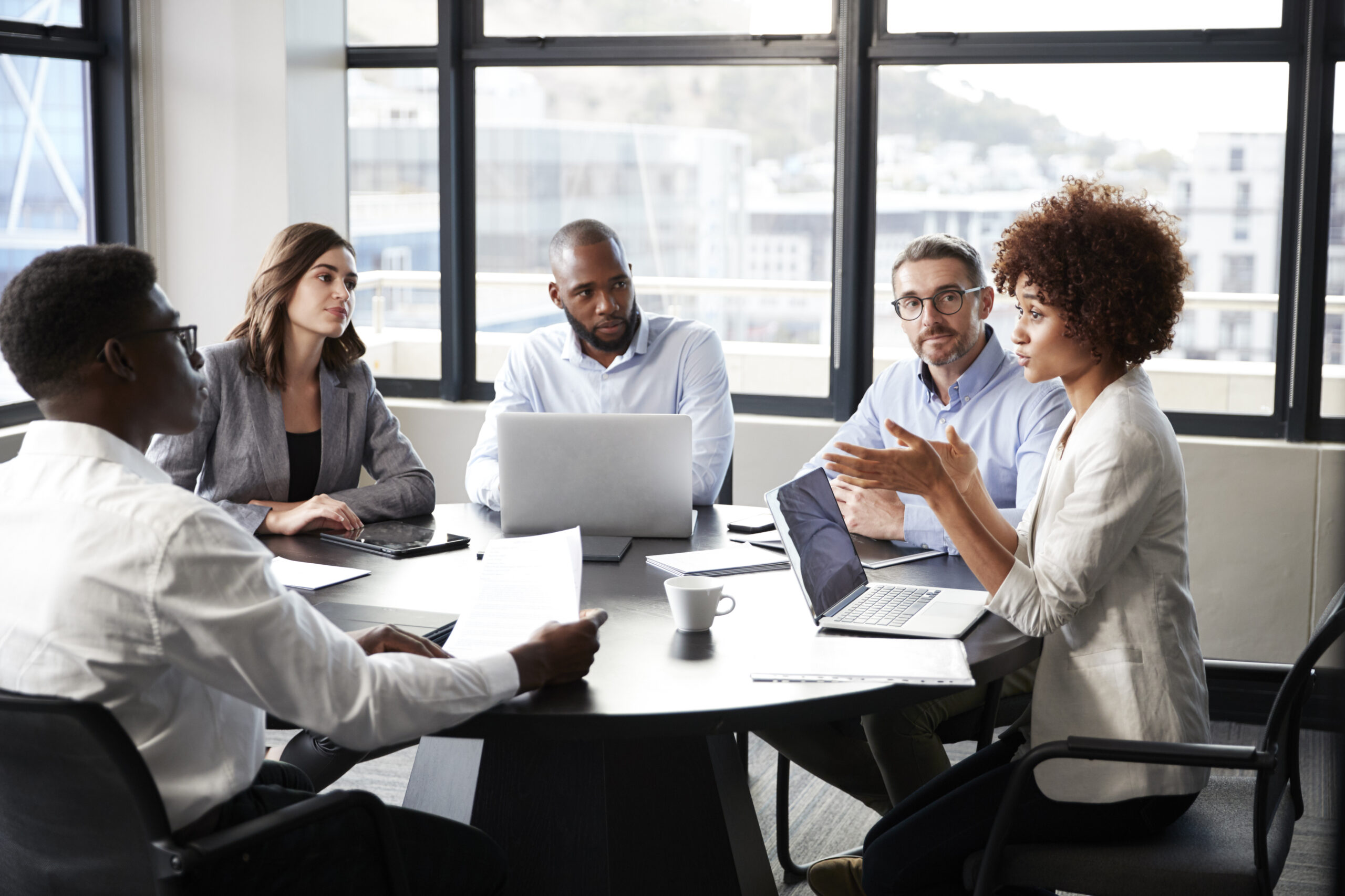 Millennial black businesswoman addressing colleagues at a corporate business meeting, close up Millennial black businesswoman addressing colleagues at a corporate business meeting, close up